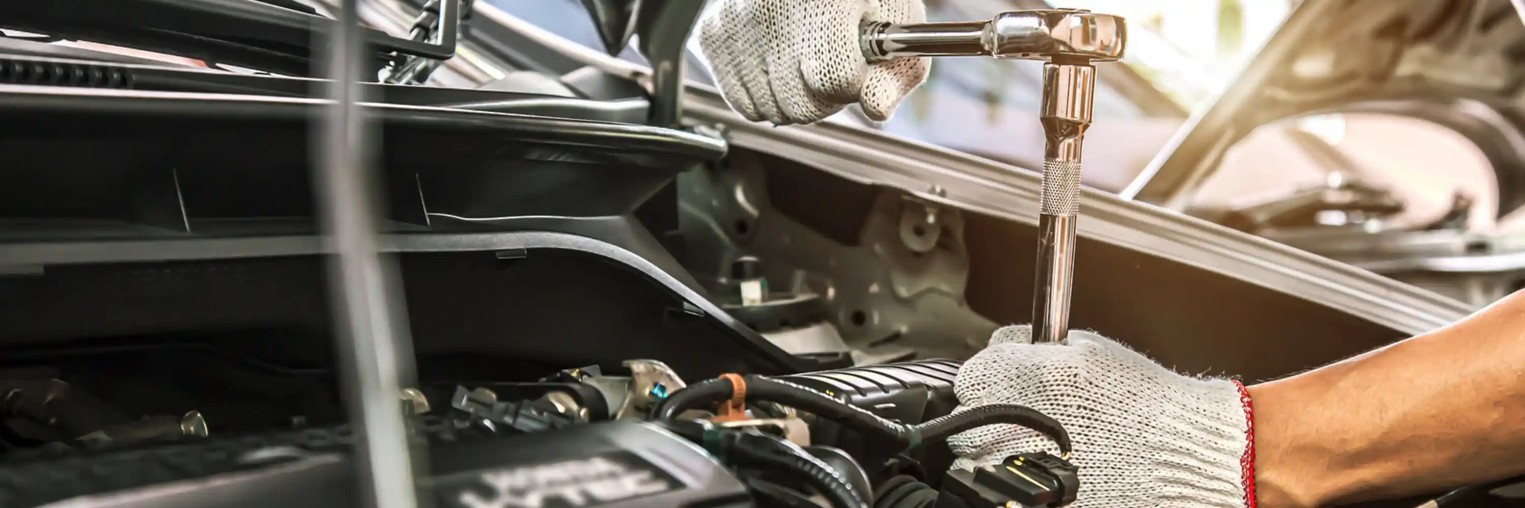 Mobile mechanic working on a car engine