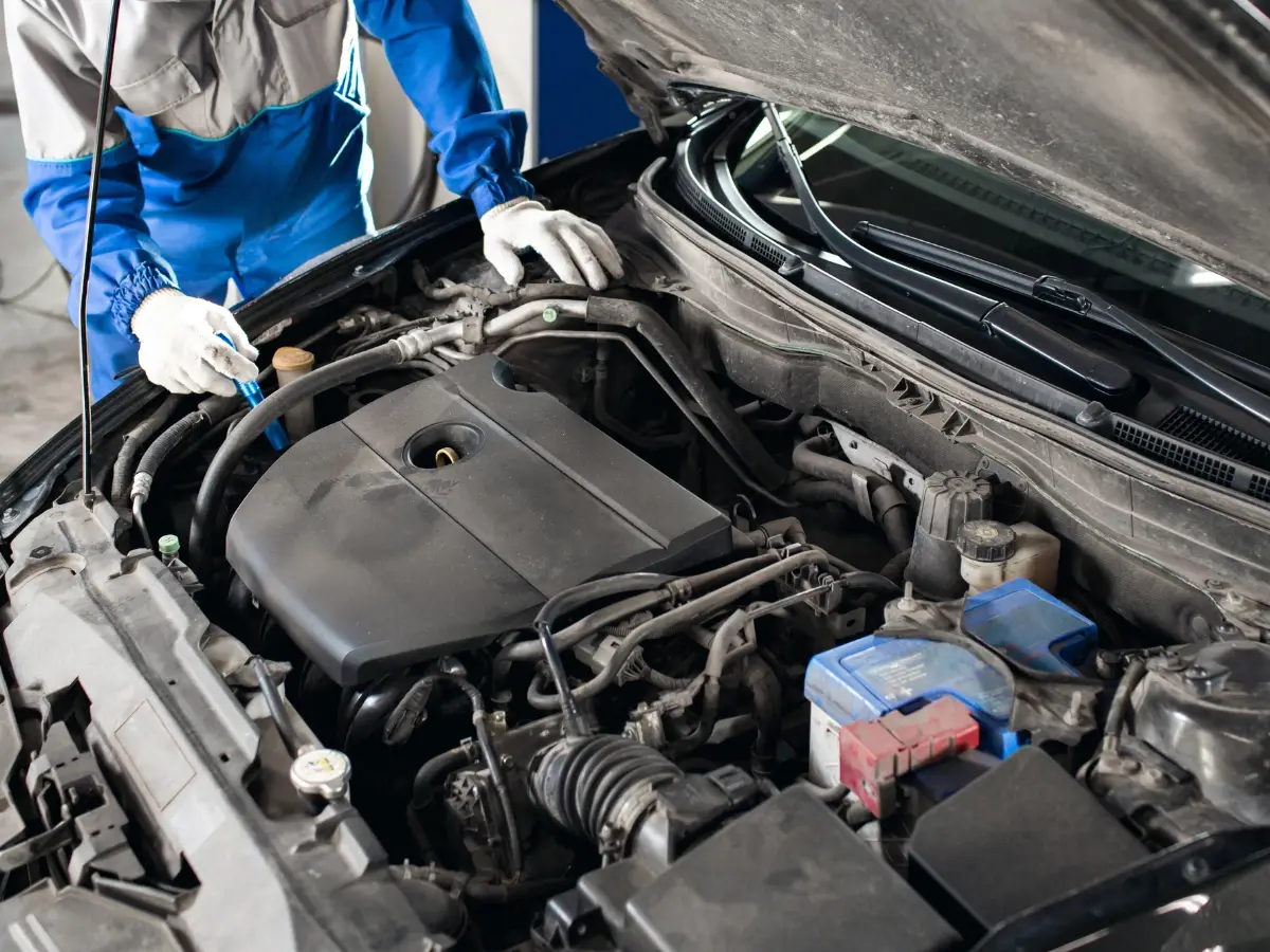 Mobile mechanic checking under the hood of a used car